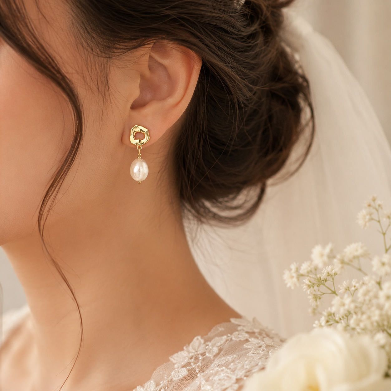 Bride wearing white baroque pearl earrings with gold open-circle studs