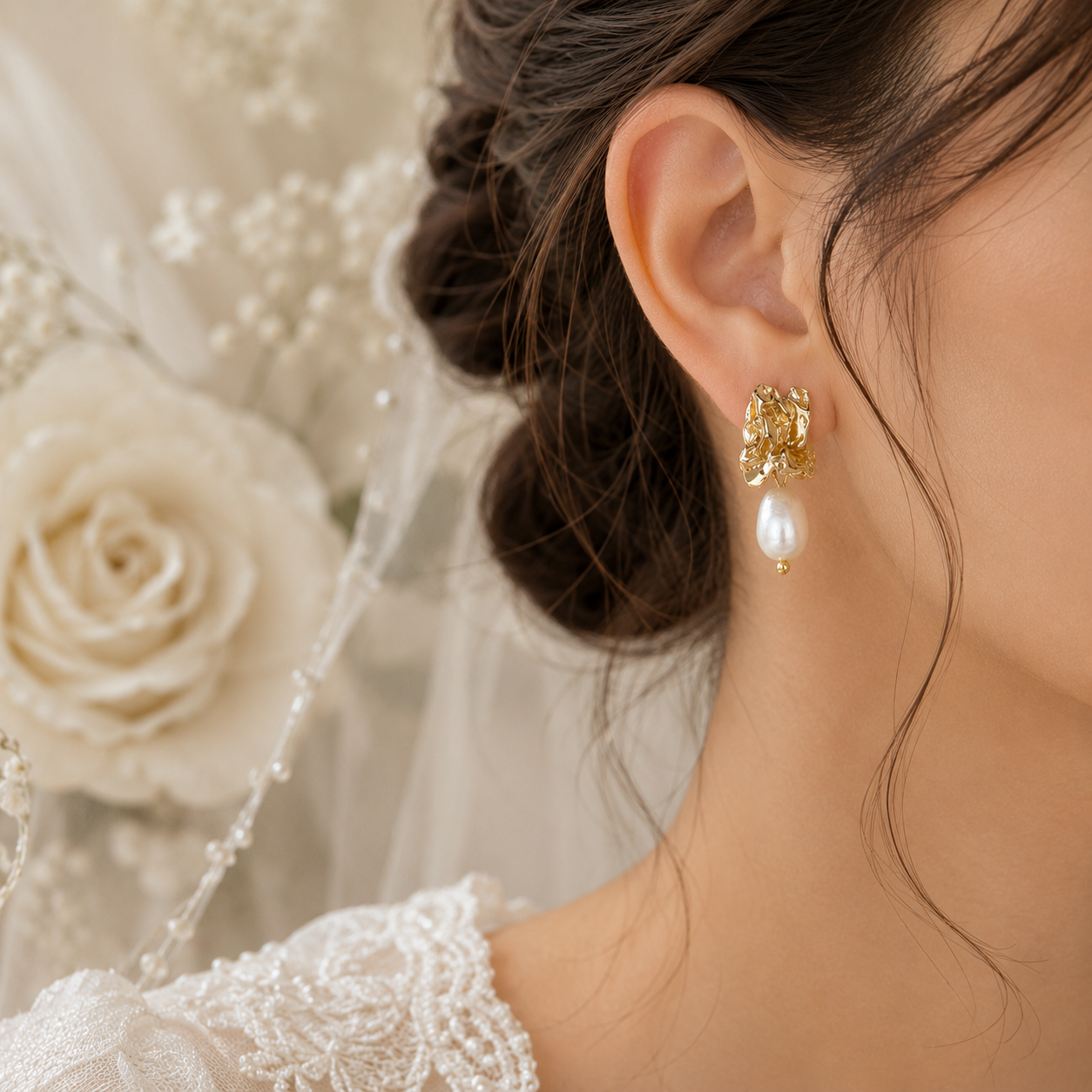 Close-up of a sculptural gold-tone earring with a white baroque freshwater pearl