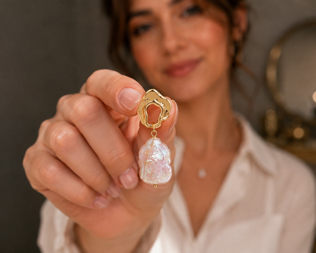 Woman holding a freshwater baroque pearl statement earring near the camera