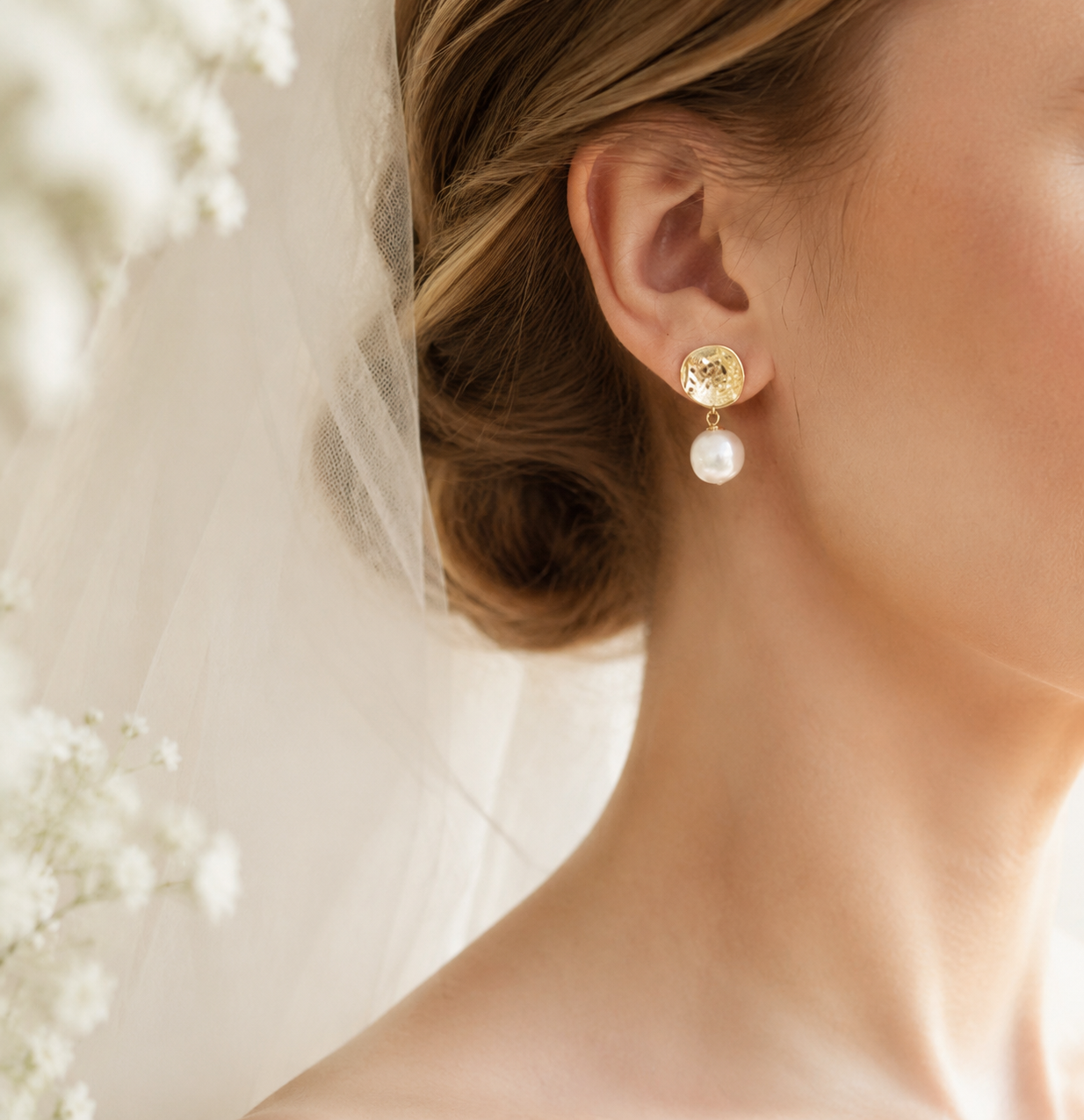 Bride wearing white baroque freshwater pearl earrings with textured gold-tone studs