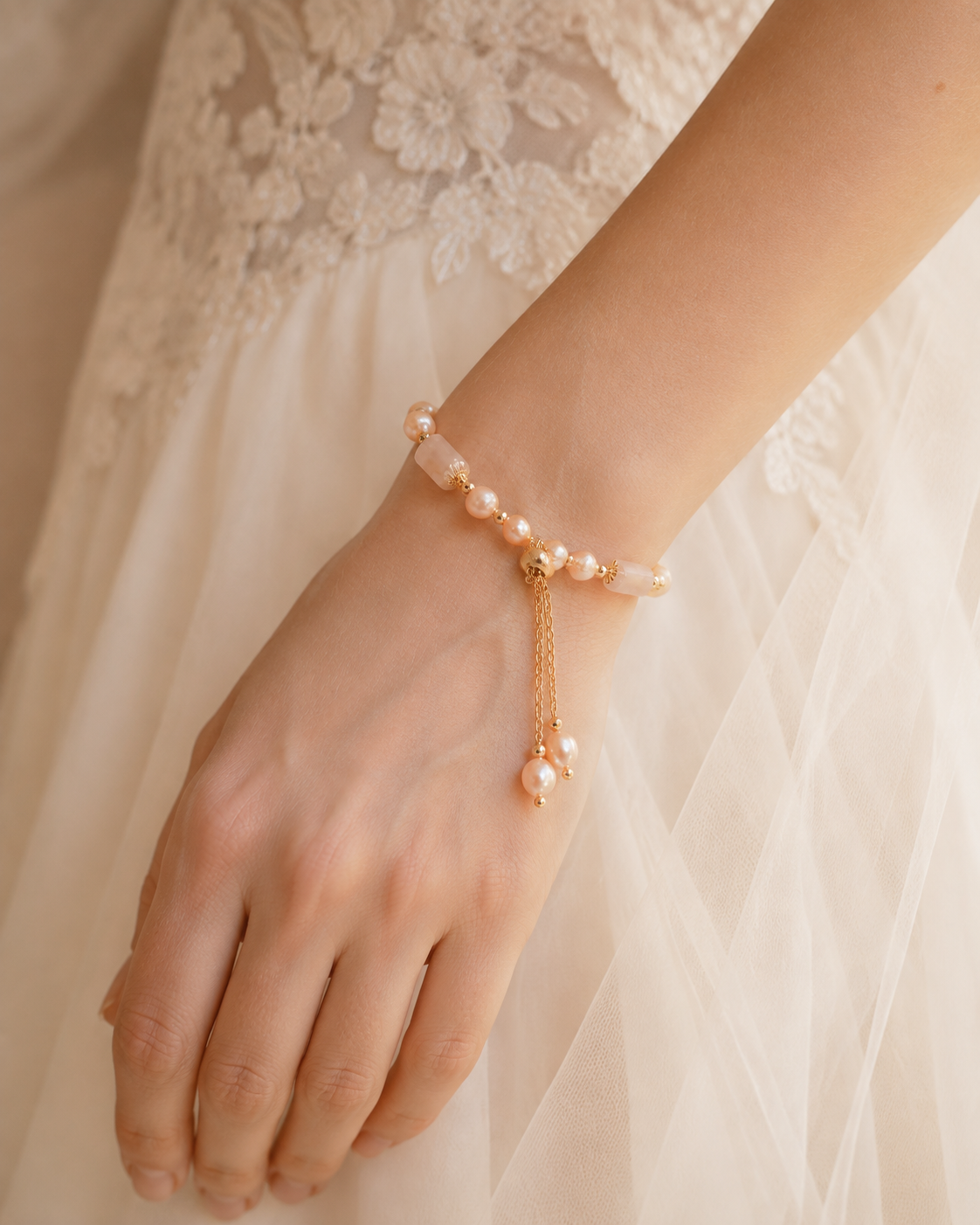 Bride wearing a champagne freshwater pearl bracelet with blush beads and an adjustable sliding closure