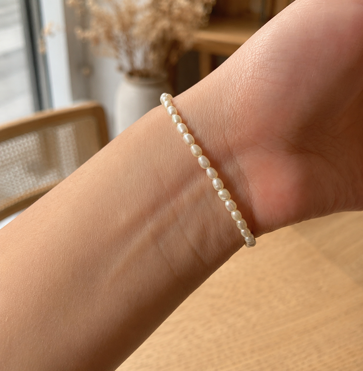 Close-up of a delicate white freshwater pearl bracelet worn on the wrist