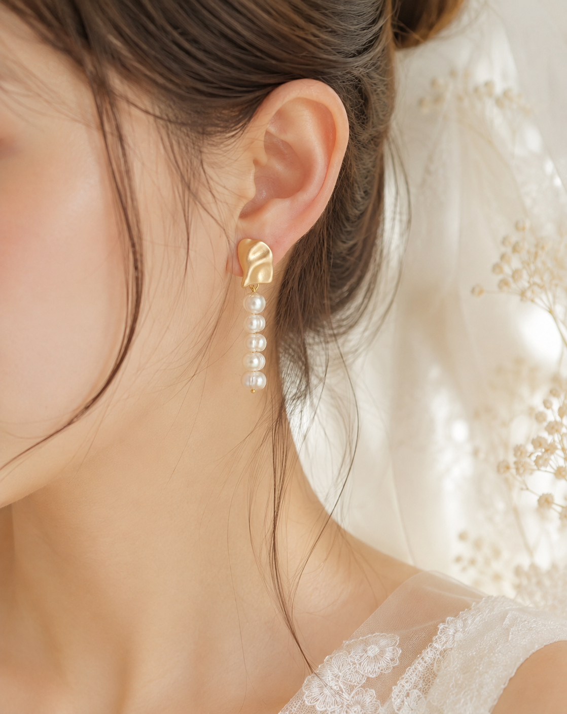 Bride wearing the five-pearl strand side of the asymmetrical earring pair