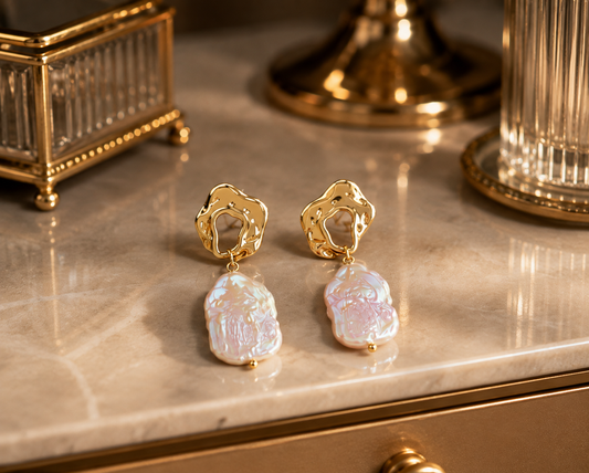 Pair of freshwater baroque pearl drop earrings displayed on a cream vanity