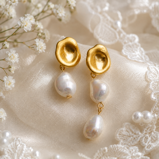Close-up of sculptural asymmetric earrings with one and two freshwater pearl drops