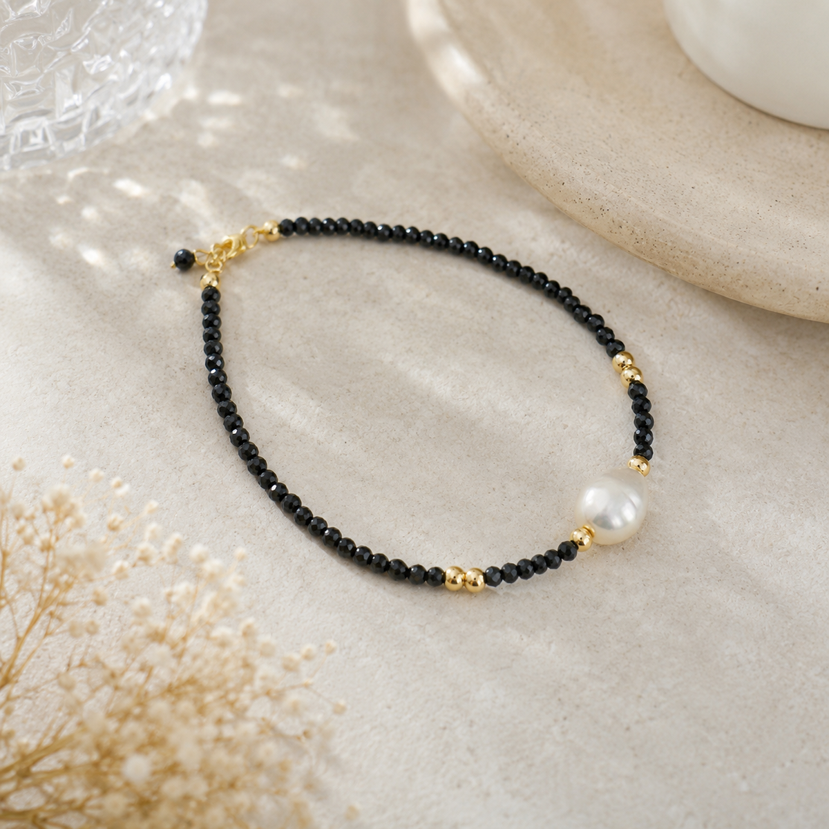 Freshwater pearl bracelet with black faceted beads, gold-tone accents and a short extension chain