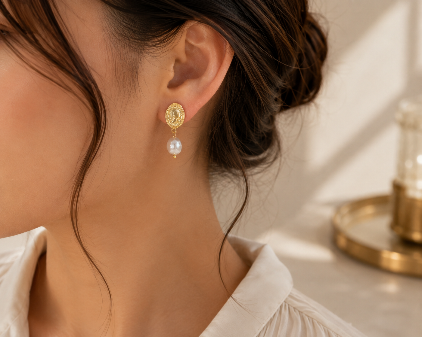 Left-side view of woman wearing freshwater pearl coin drop earrings