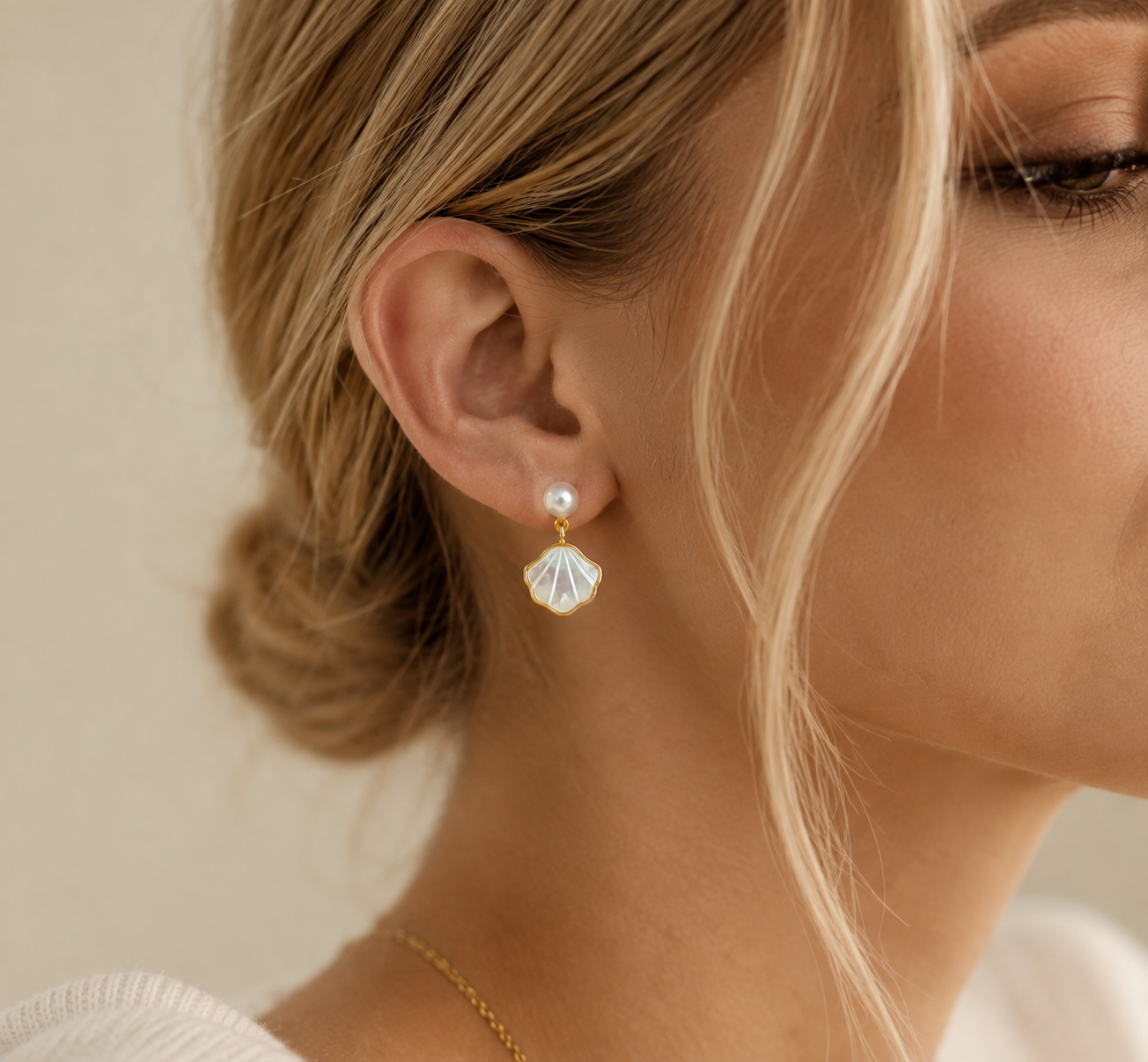 Freshwater pearl shell drop earrings shown from behind the ear