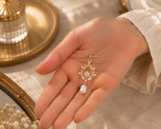 Freshwater pearl floral filigree drop earring displayed in a hand