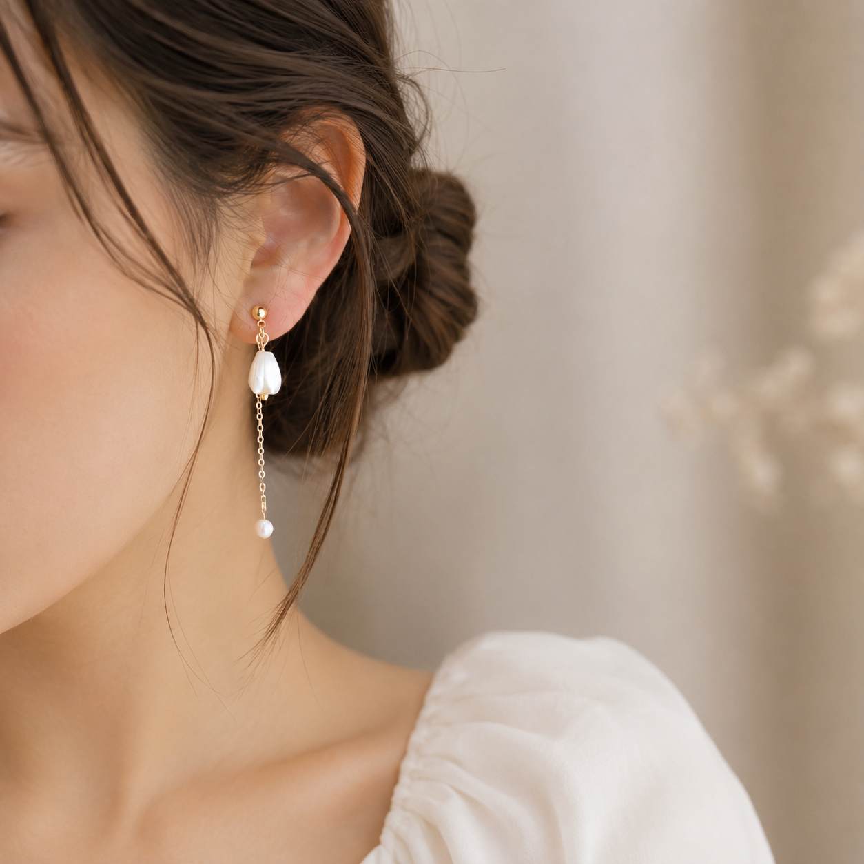 Close-up of the long asymmetric floral earring with a pearl chain drop