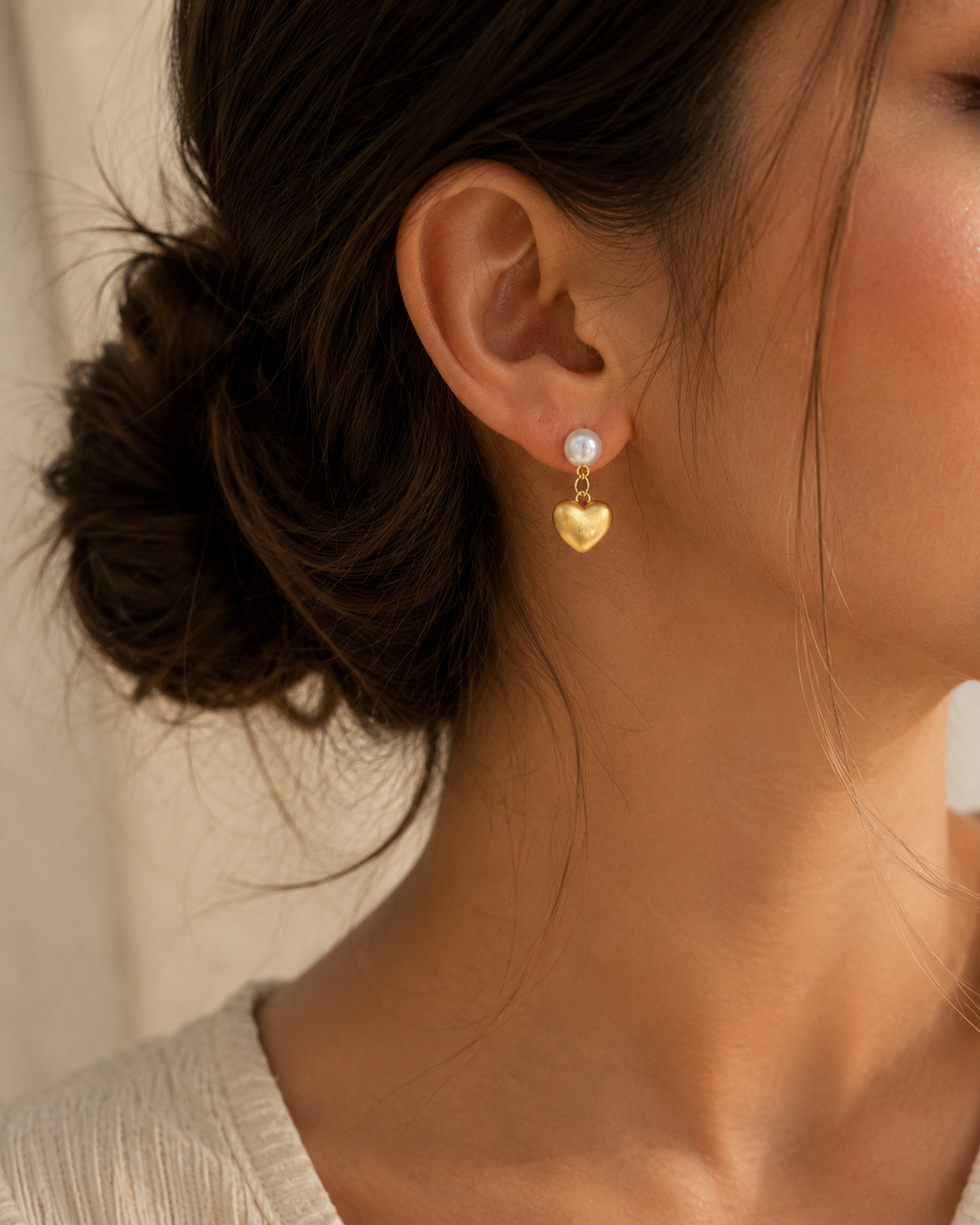 Close-up of woman wearing freshwater pearl heart drop earrings