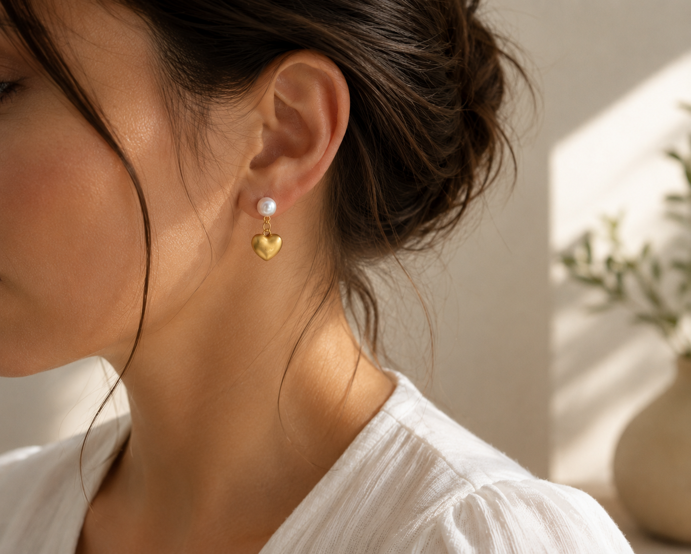 Woman wearing freshwater pearl heart drop earrings in natural light