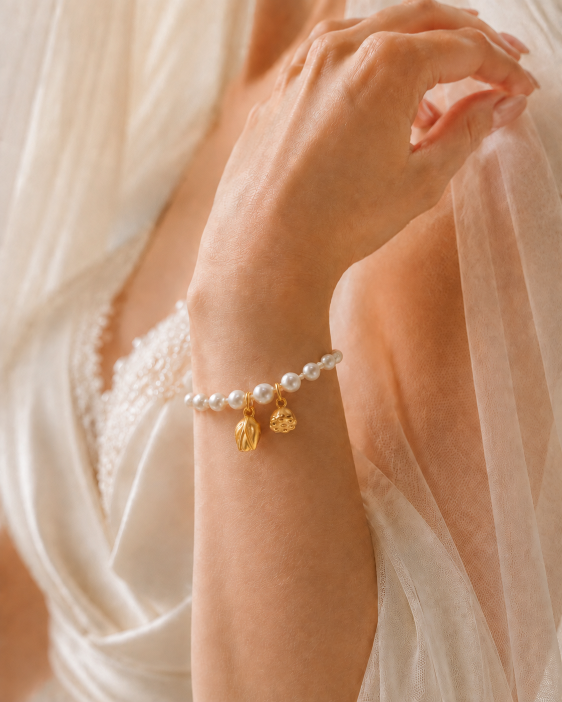 Bride wearing a double-strand freshwater pearl bracelet with two gold-tone lotus charms
