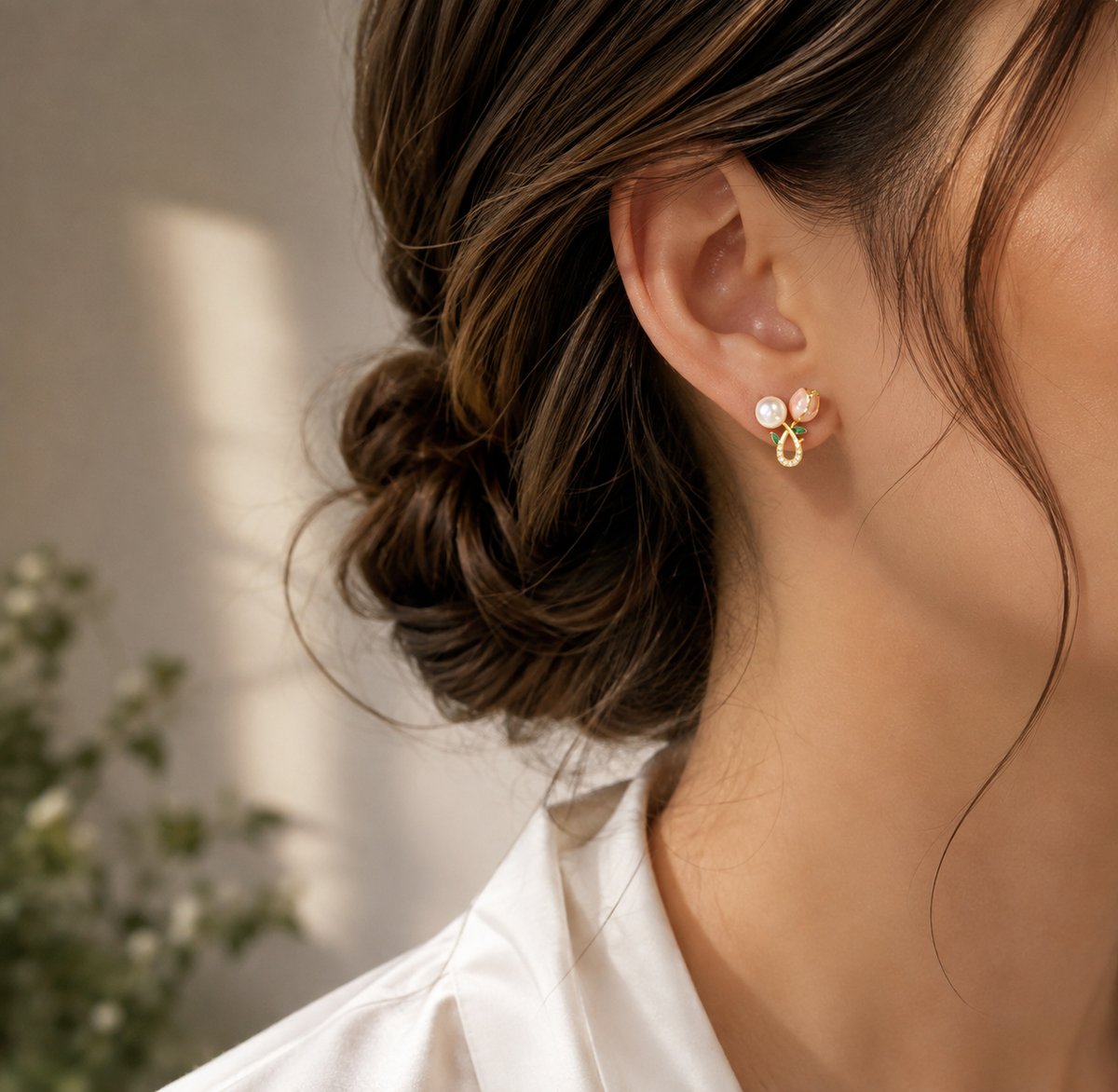 Woman wearing pink and green floral earrings with freshwater pearl accents