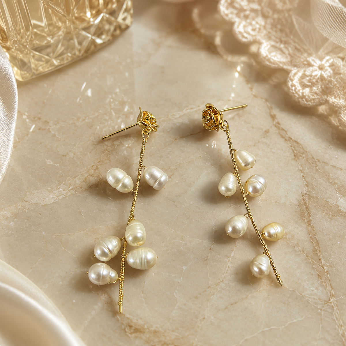 Detailed view of freshwater pearl rose vine earrings arranged on a stone surface