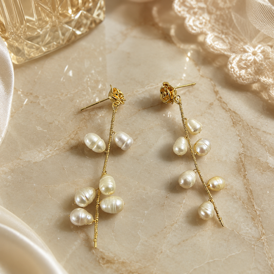 Detailed view of freshwater pearl rose vine earrings arranged on a stone surface