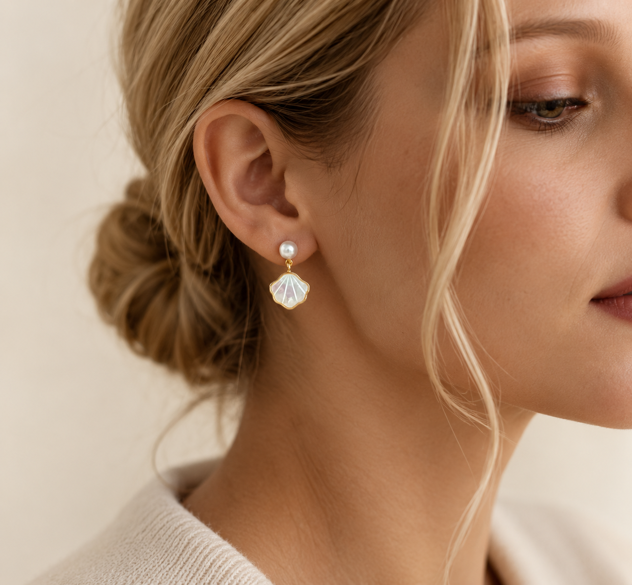 Woman wearing freshwater pearl shell drop earrings with a bridal hairstyle