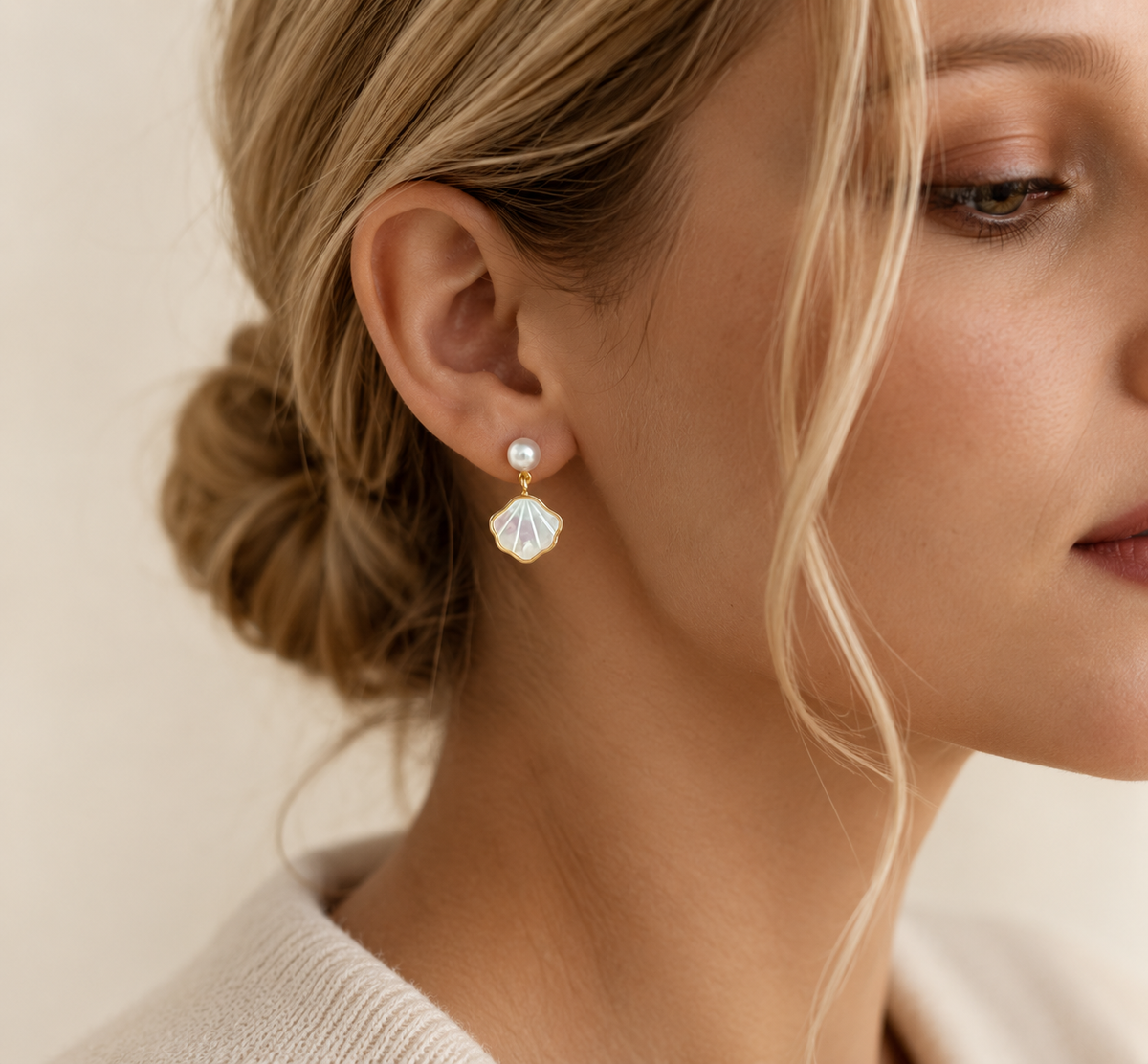 Woman wearing freshwater pearl shell drop earrings with a bridal hairstyle