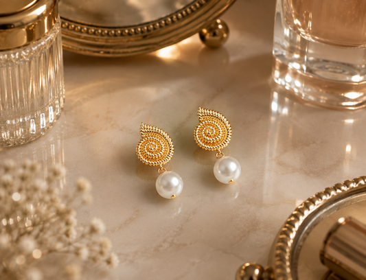 Pair of freshwater pearl spiral drop earrings displayed on a cream vanity