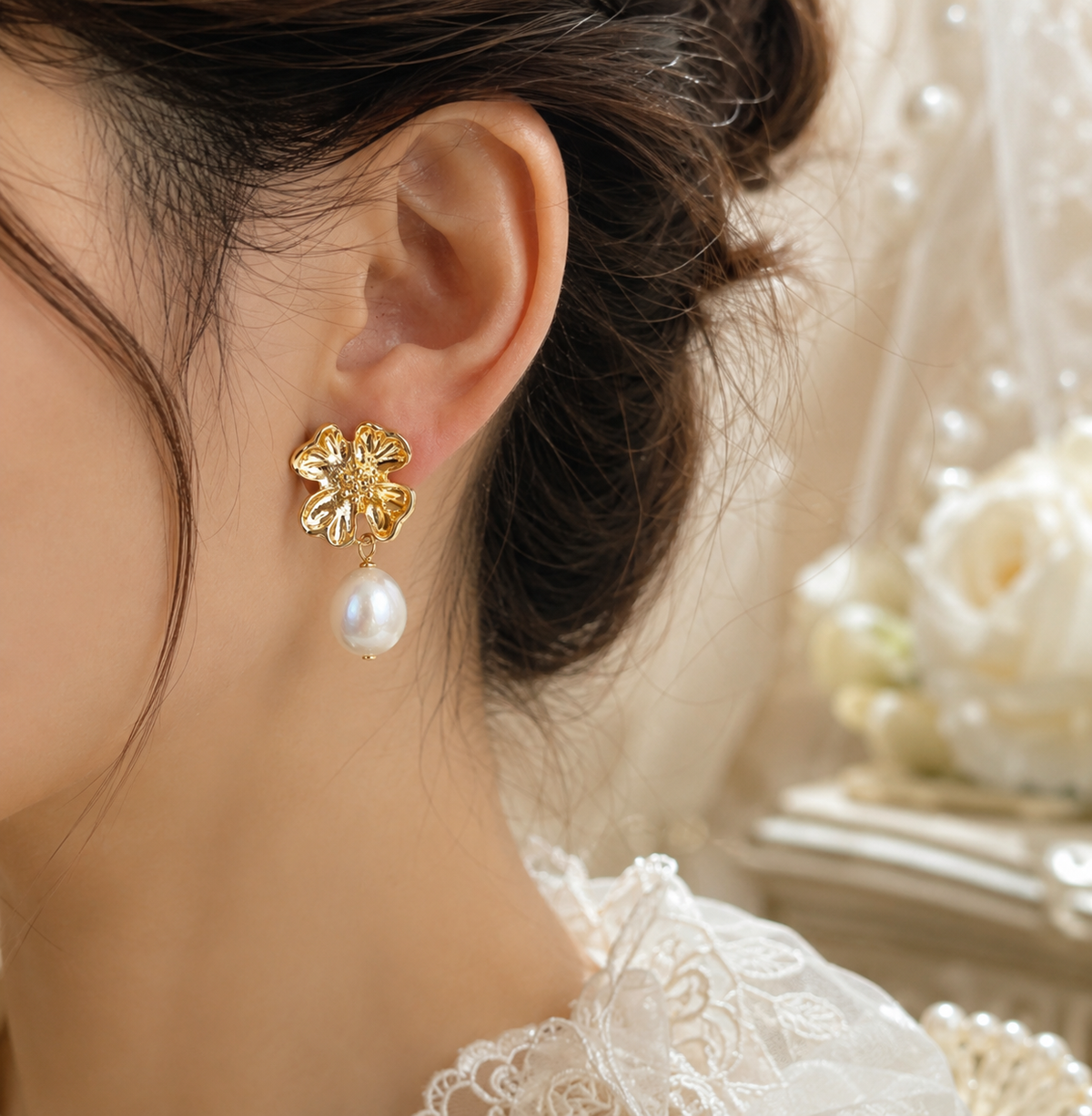 Bride wearing gold blossom earrings with white baroque freshwater pearl drops