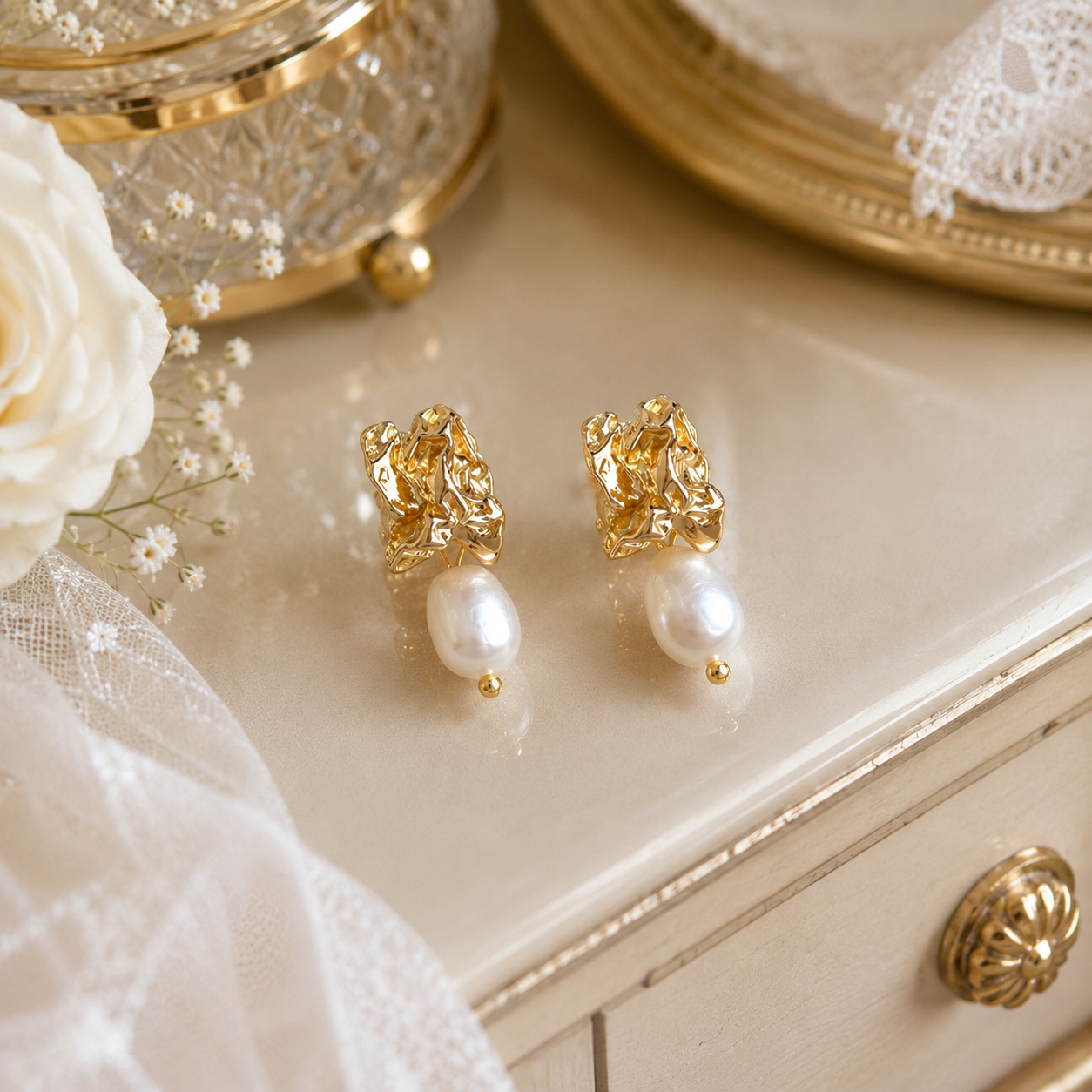 Pair of gold sculptural dangle earrings with white freshwater pearl drops