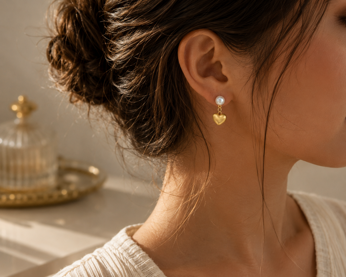 Right-side view of gold-tone freshwater pearl heart drop earrings