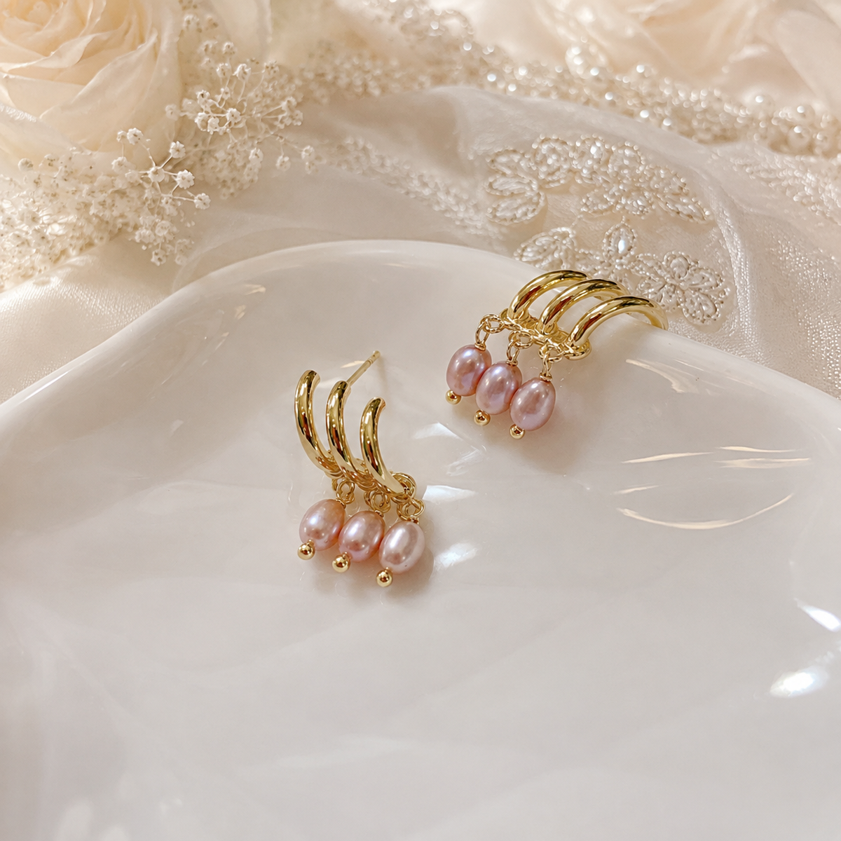 Pair of gold-tone triple hoop earrings with three oval pink freshwater pearl drops on each earring