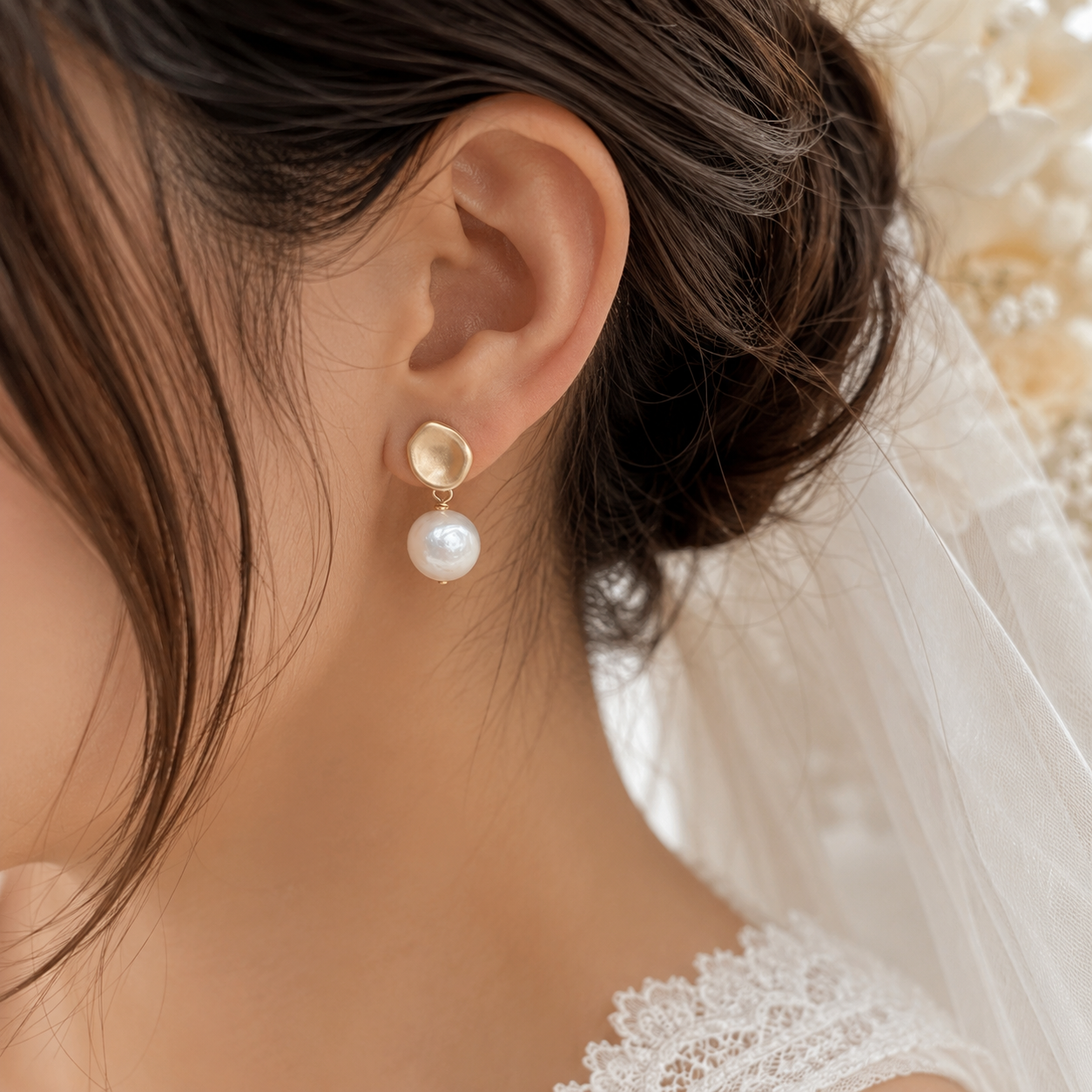 Bride wearing a white baroque freshwater pearl earring with a matte gold-tone stud