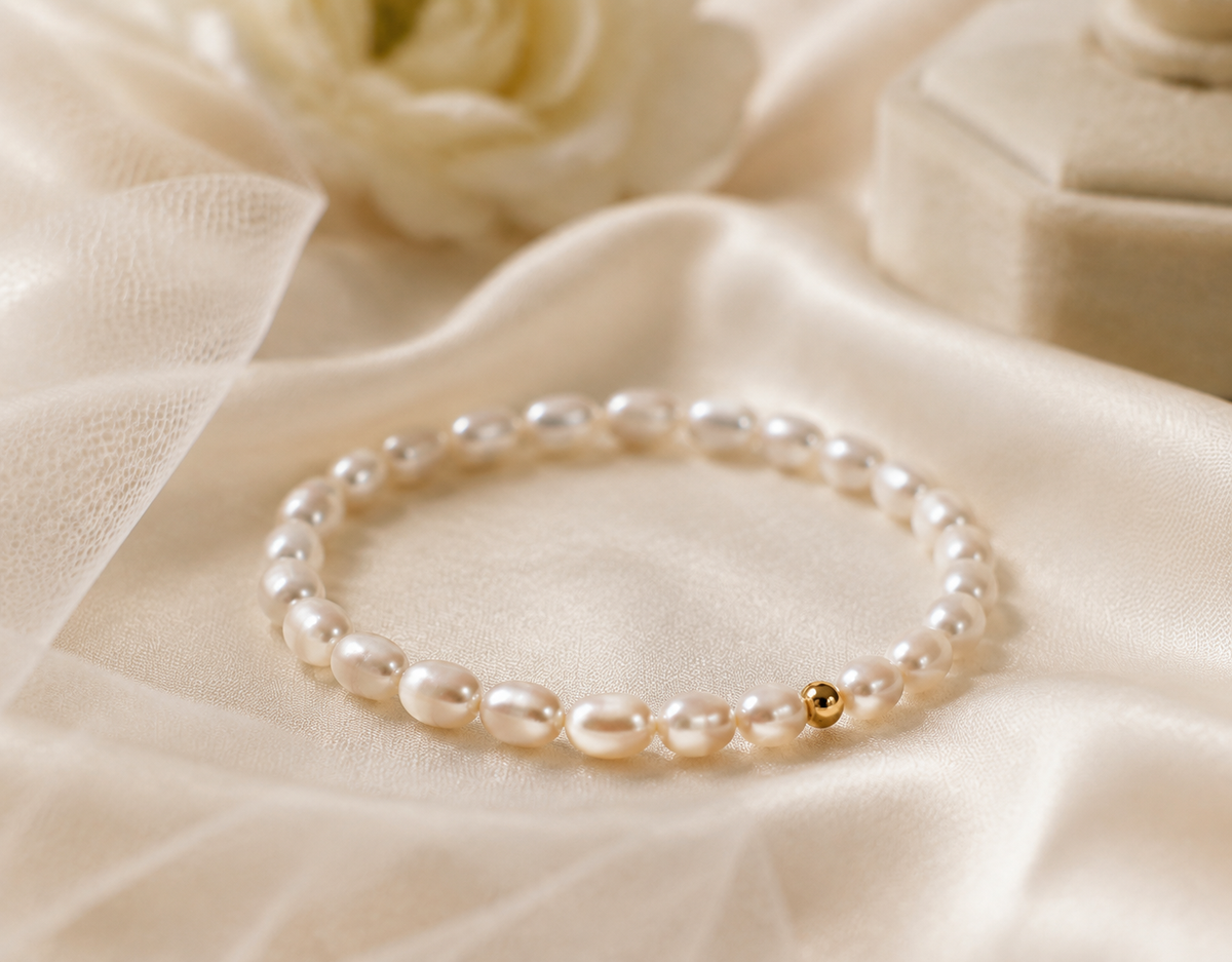 Close-up of a minimalist white rice freshwater pearl bracelet with one gold-tone bead