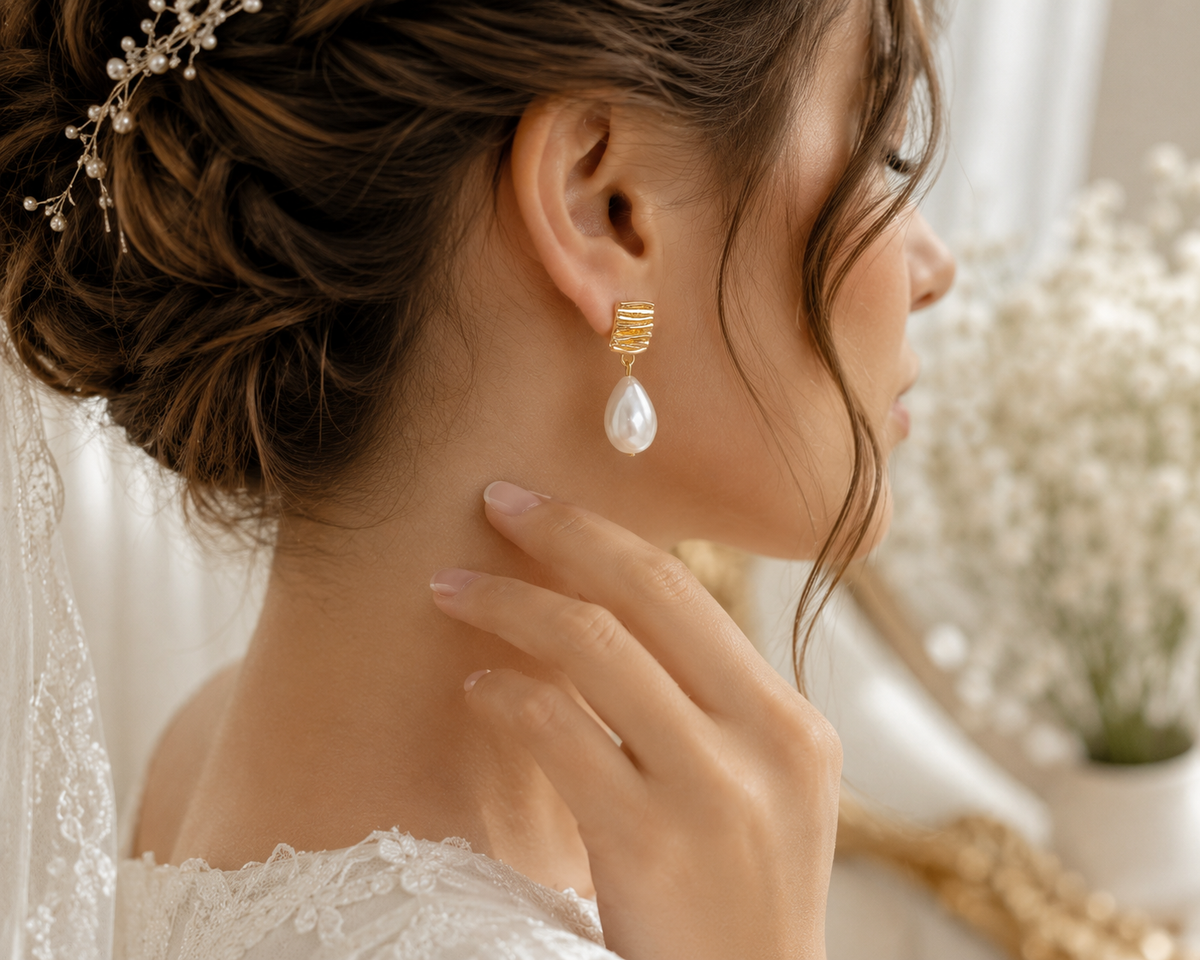 Modern teardrop pearl earrings completing an elegant wedding hairstyle