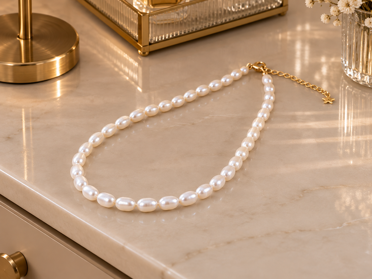 Natural white freshwater rice pearl necklace displayed on a marble surface