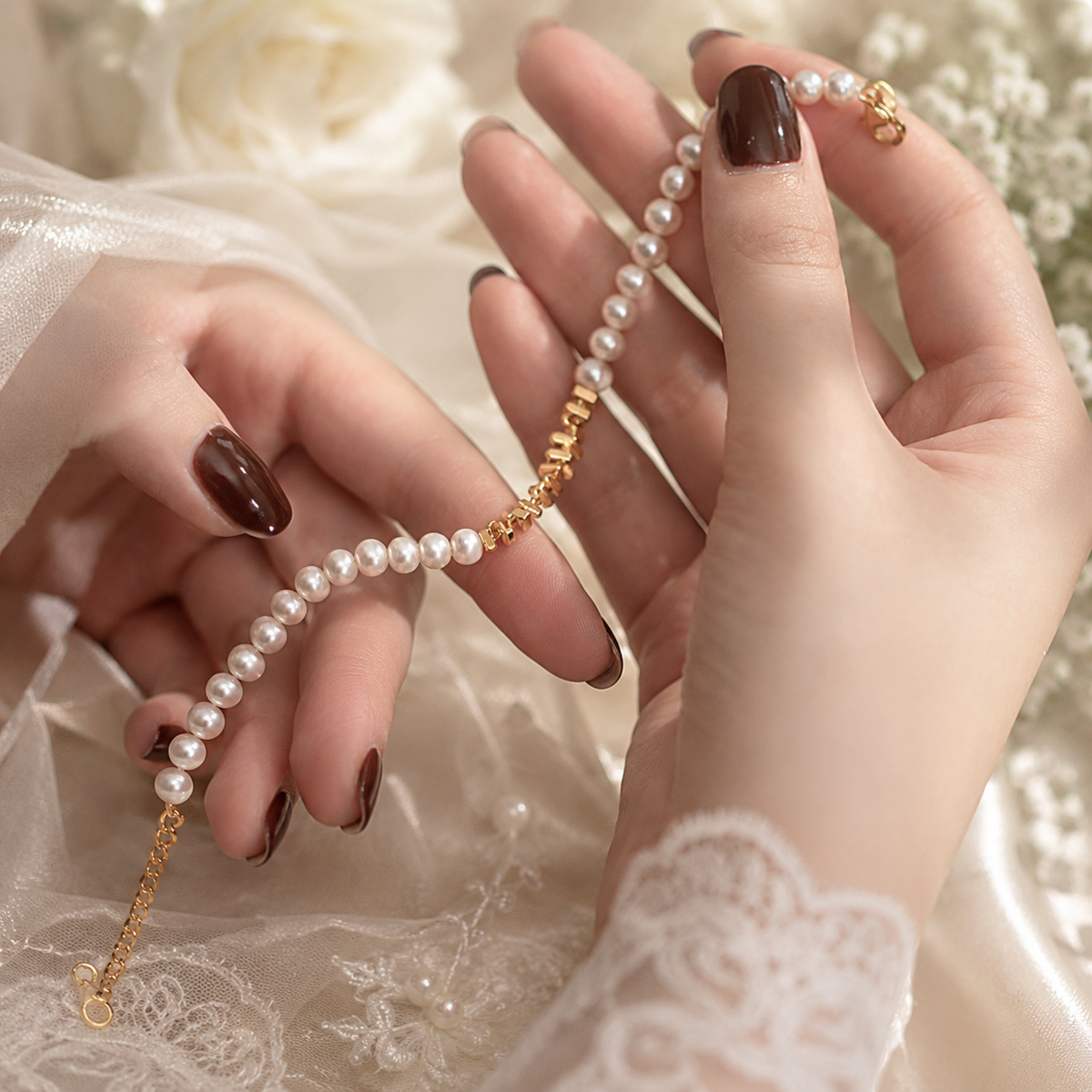 Close-up of a white pearl bracelet with polished gold-tone geometric beads and an extension chain