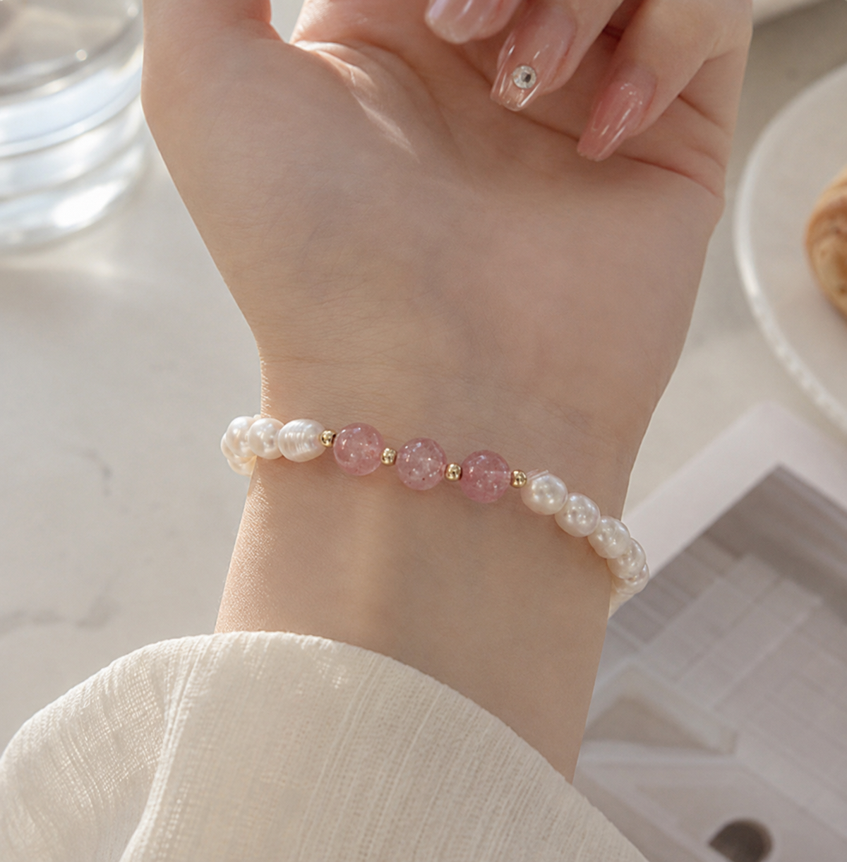 White pearl stretch bracelet with translucent pink beads and small gold-tone accents