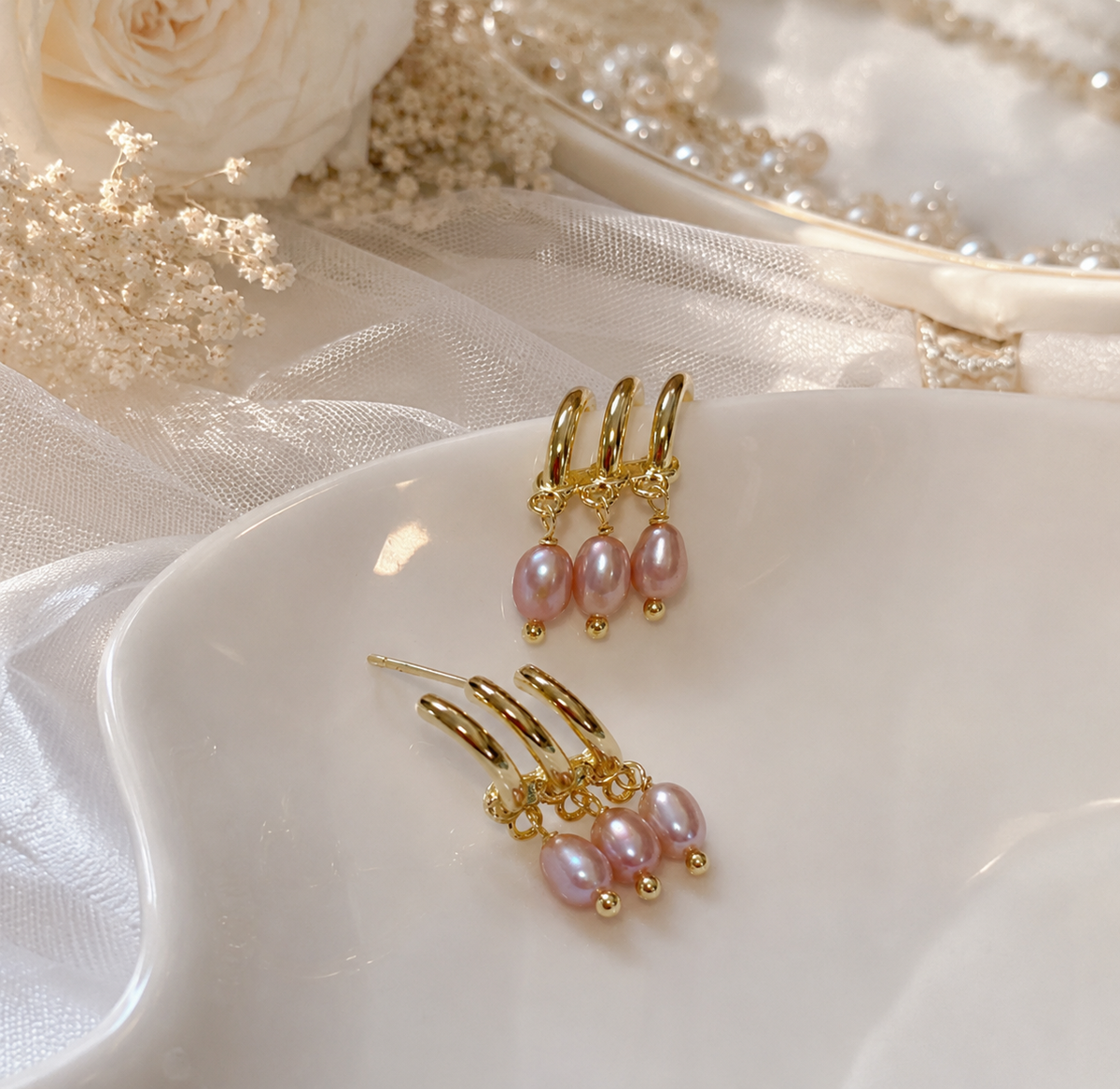 Pink freshwater pearl triple hoop drop earrings displayed on a white bridal jewelry tray