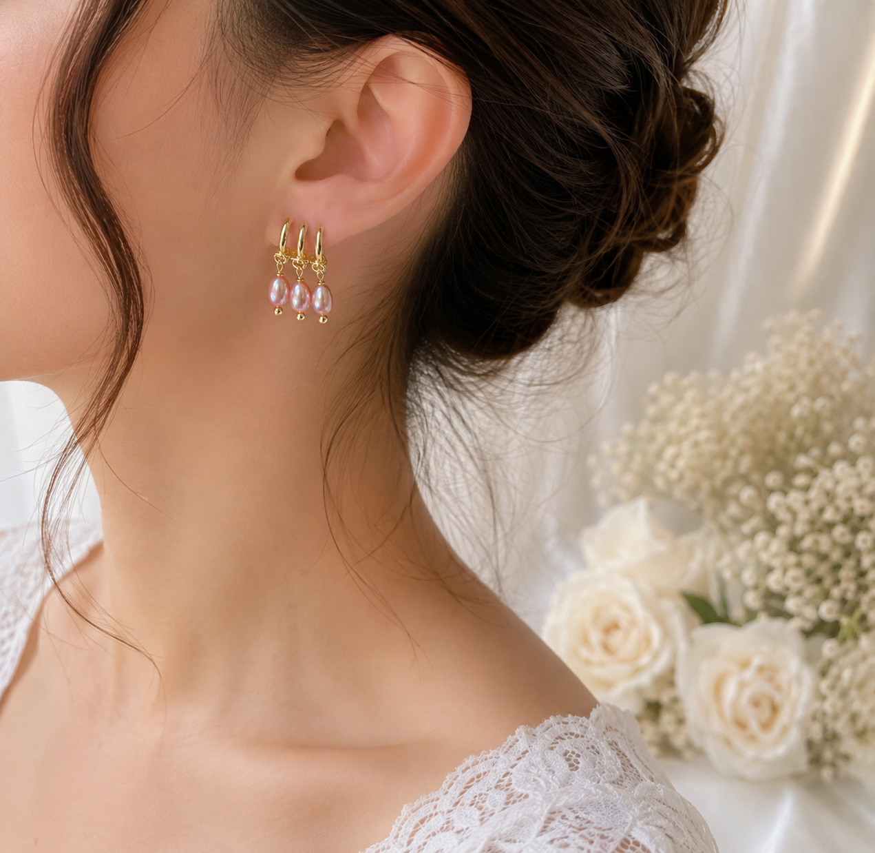 Bride wearing pink freshwater pearl triple hoop drop earrings with an elegant bridal hairstyle