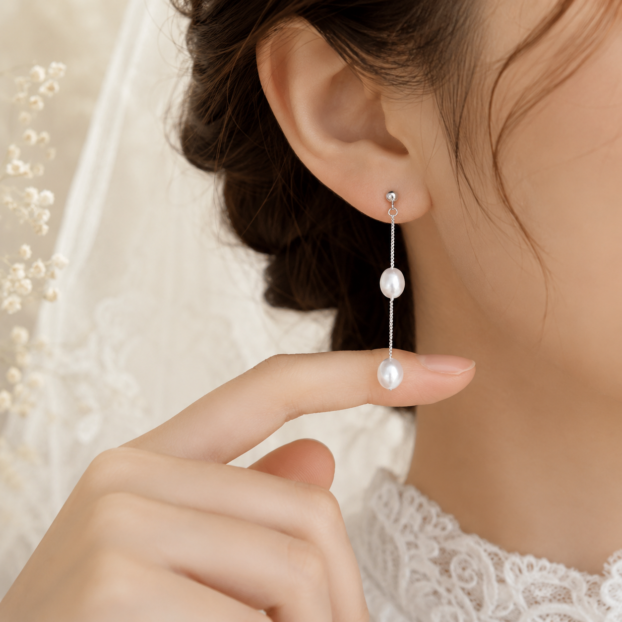 Bride wearing long S925 sterling silver chain earrings with white freshwater pearls