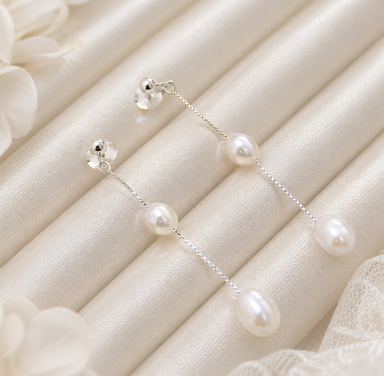 Close-up of S925 sterling silver chain earrings with polished ball studs and freshwater pearls
