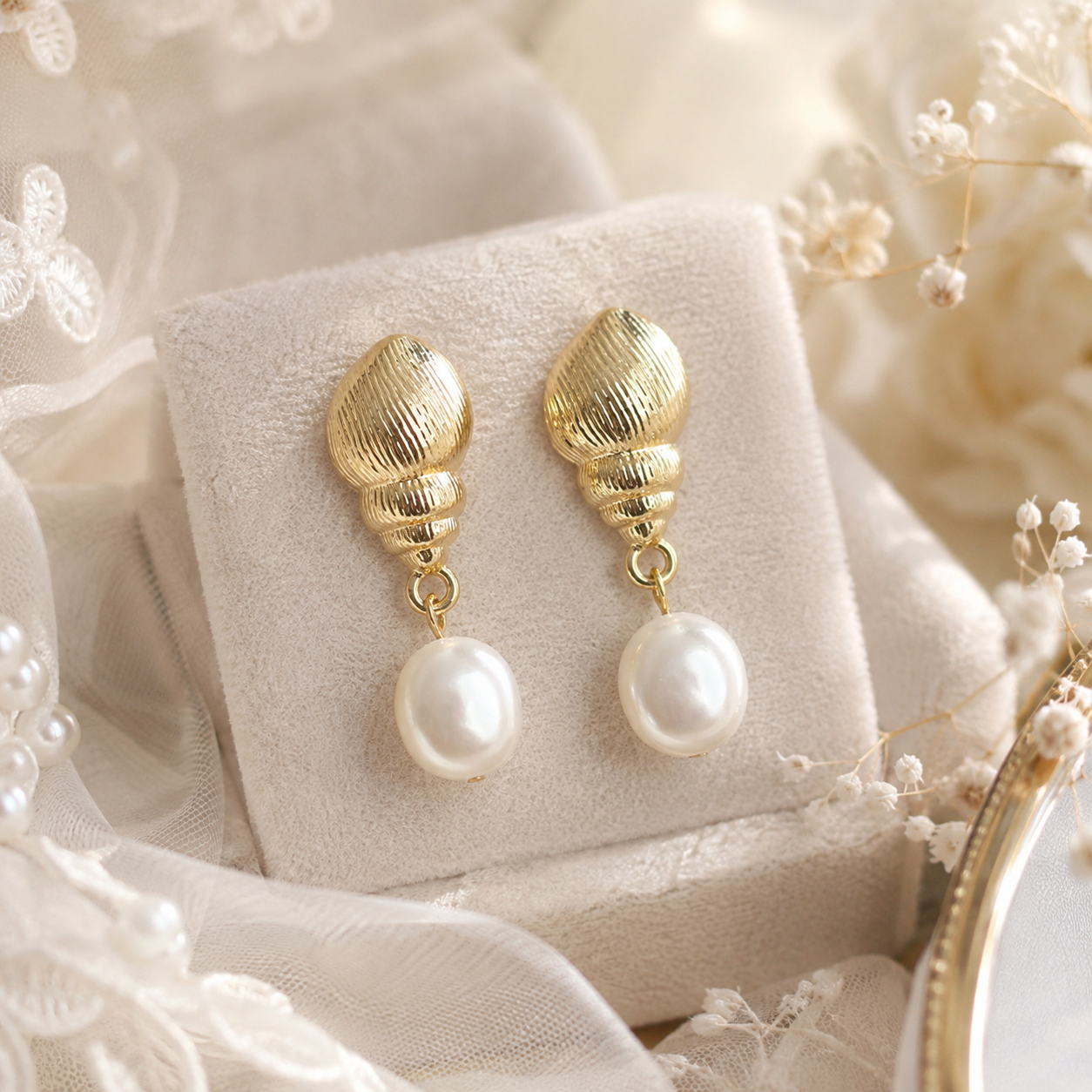 White freshwater pearl dangle earrings with textured shell-inspired gold-tone studs