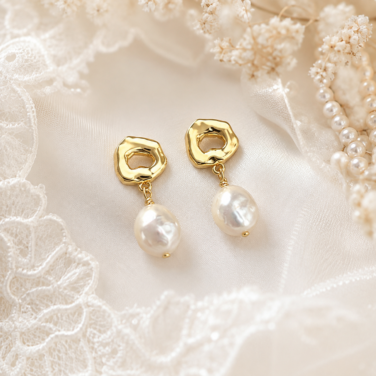 Pair of white baroque freshwater pearl dangle earrings with sculptural gold-tone studs