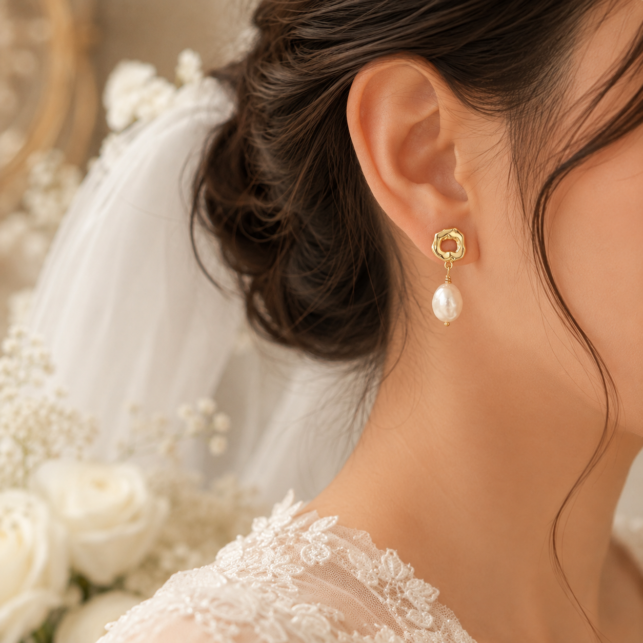 Close-up of a gold-tone open-circle earring with a white baroque freshwater pearl
