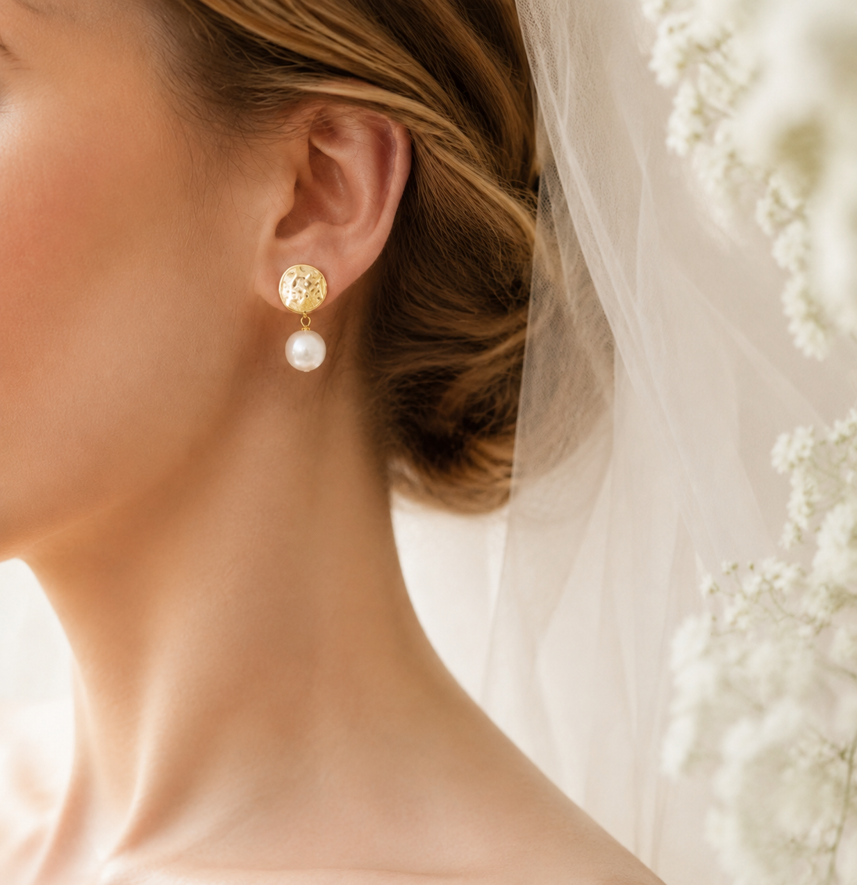 Side view of white baroque pearl drop earrings styled with a bridal veil