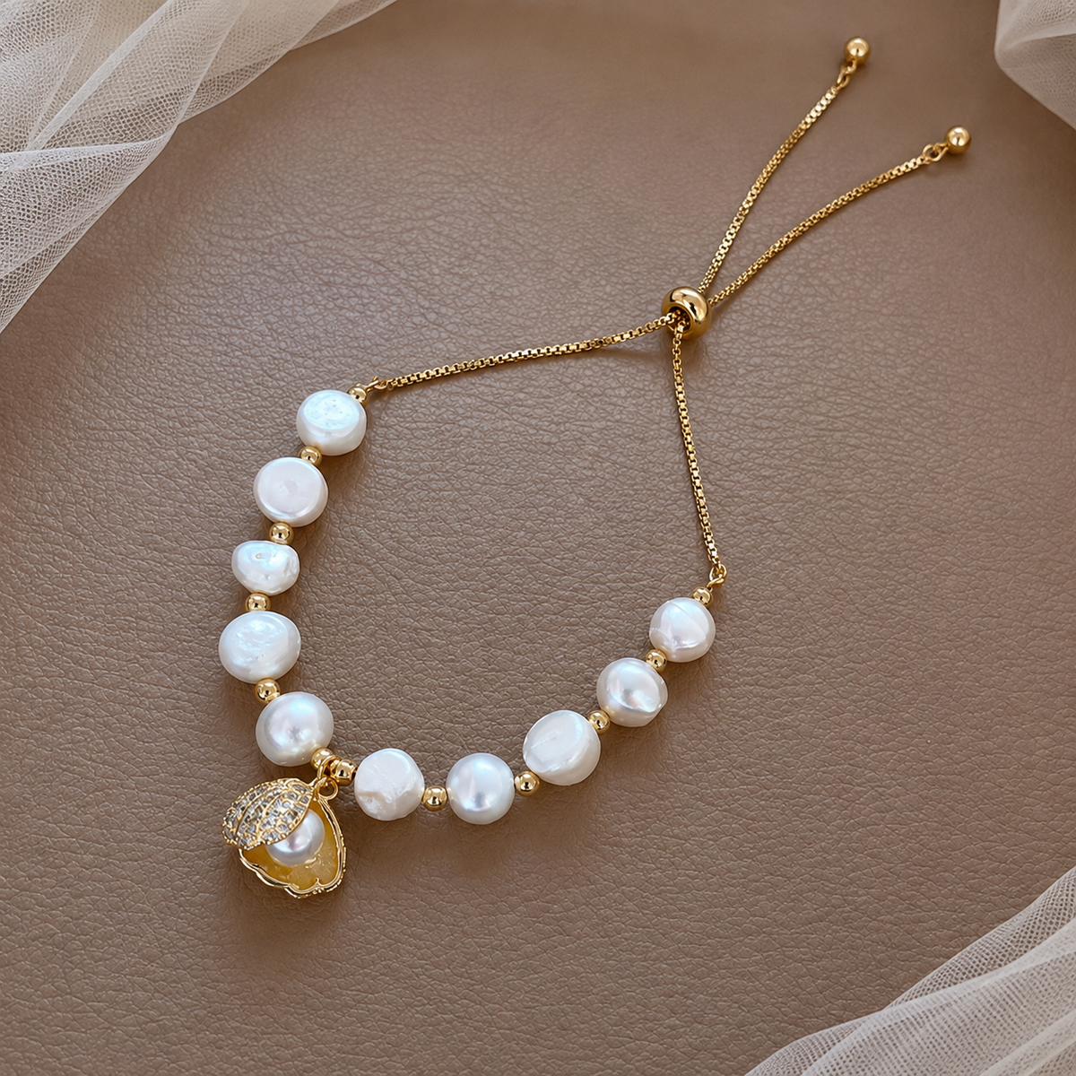 White baroque freshwater pearl bracelet with a gold-tone shell charm and adjustable sliding closure