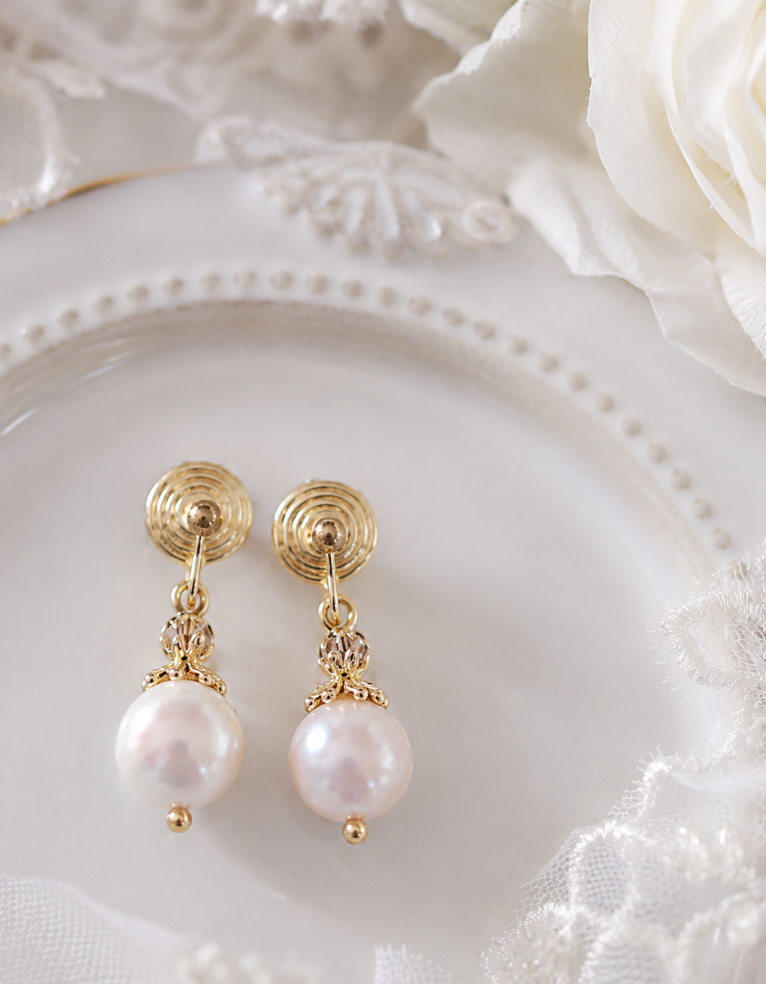 Pair of white freshwater pearl drop earrings with gold-tone spiral studs