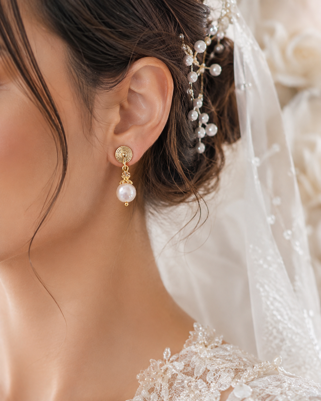 Bride wearing white freshwater pearl drop earrings with gold spiral studs