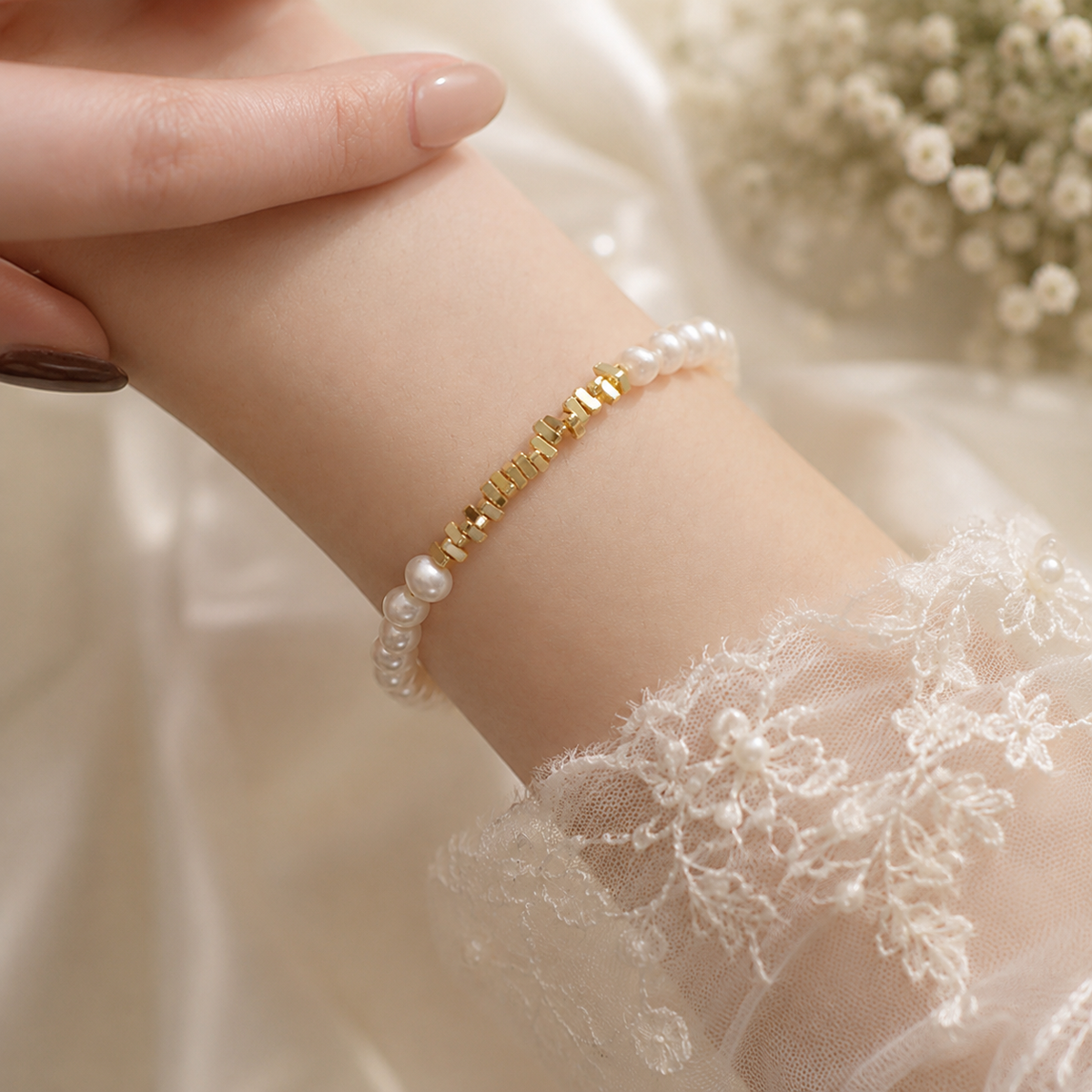 White pearl and gold-tone beaded bracelet worn on a bride’s wrist