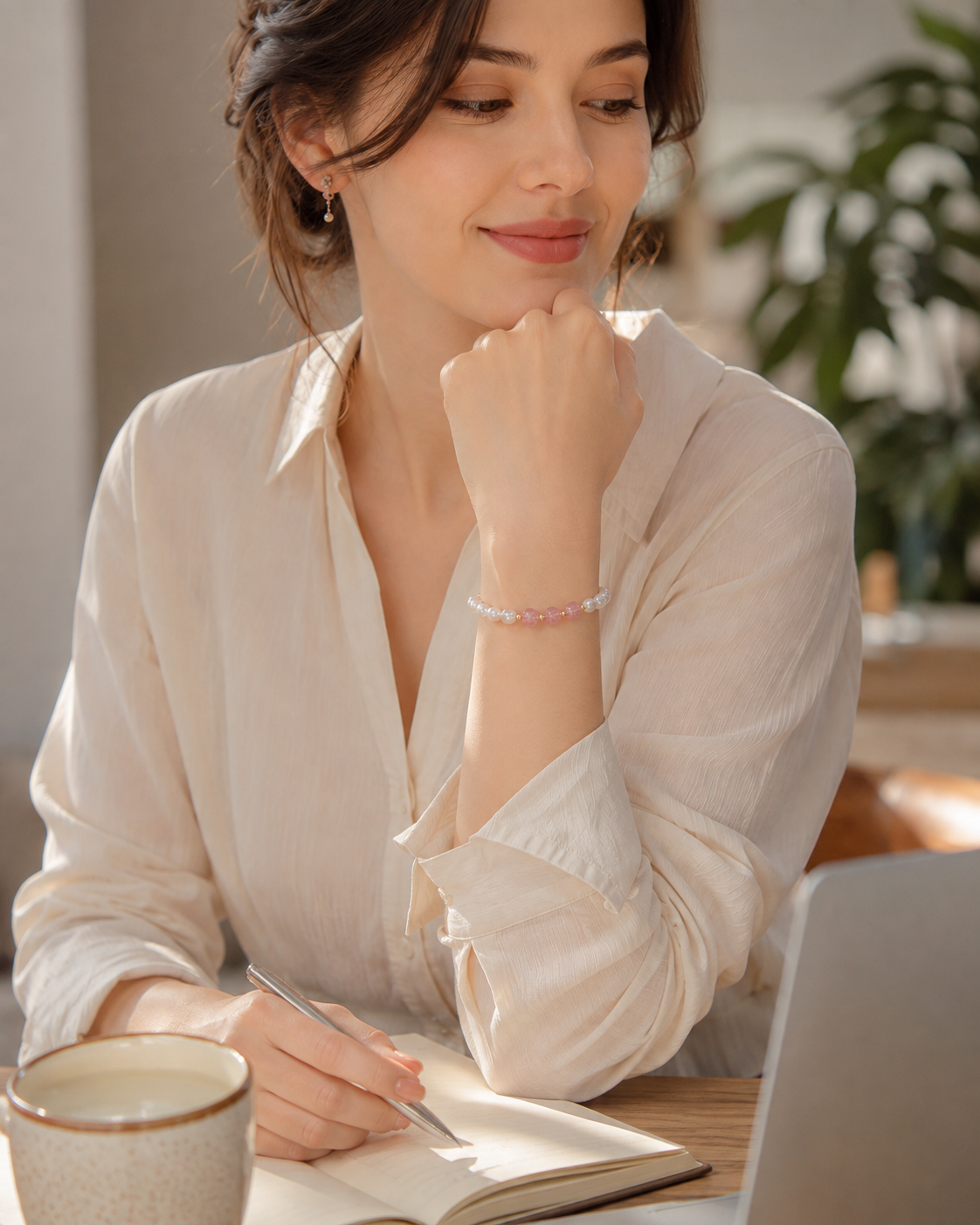 White pearl stretch bracelet featuring translucent pink centerpiece beads and gold-tone spacers